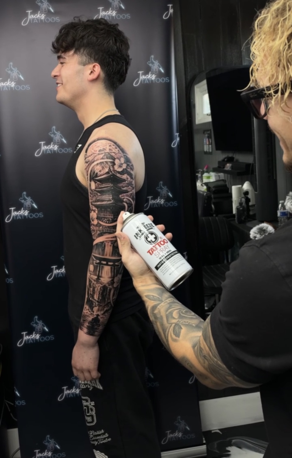Jack applying aftercare spray to a freshly finished Japanese sleeve tattoo