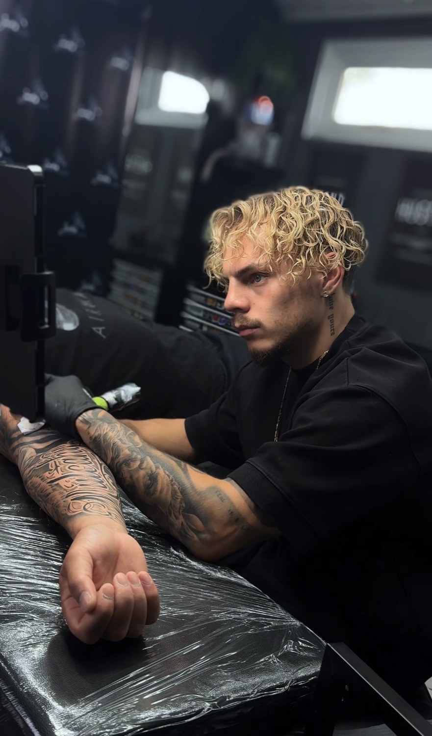 Jack lining up a stencil on a client's forearm
