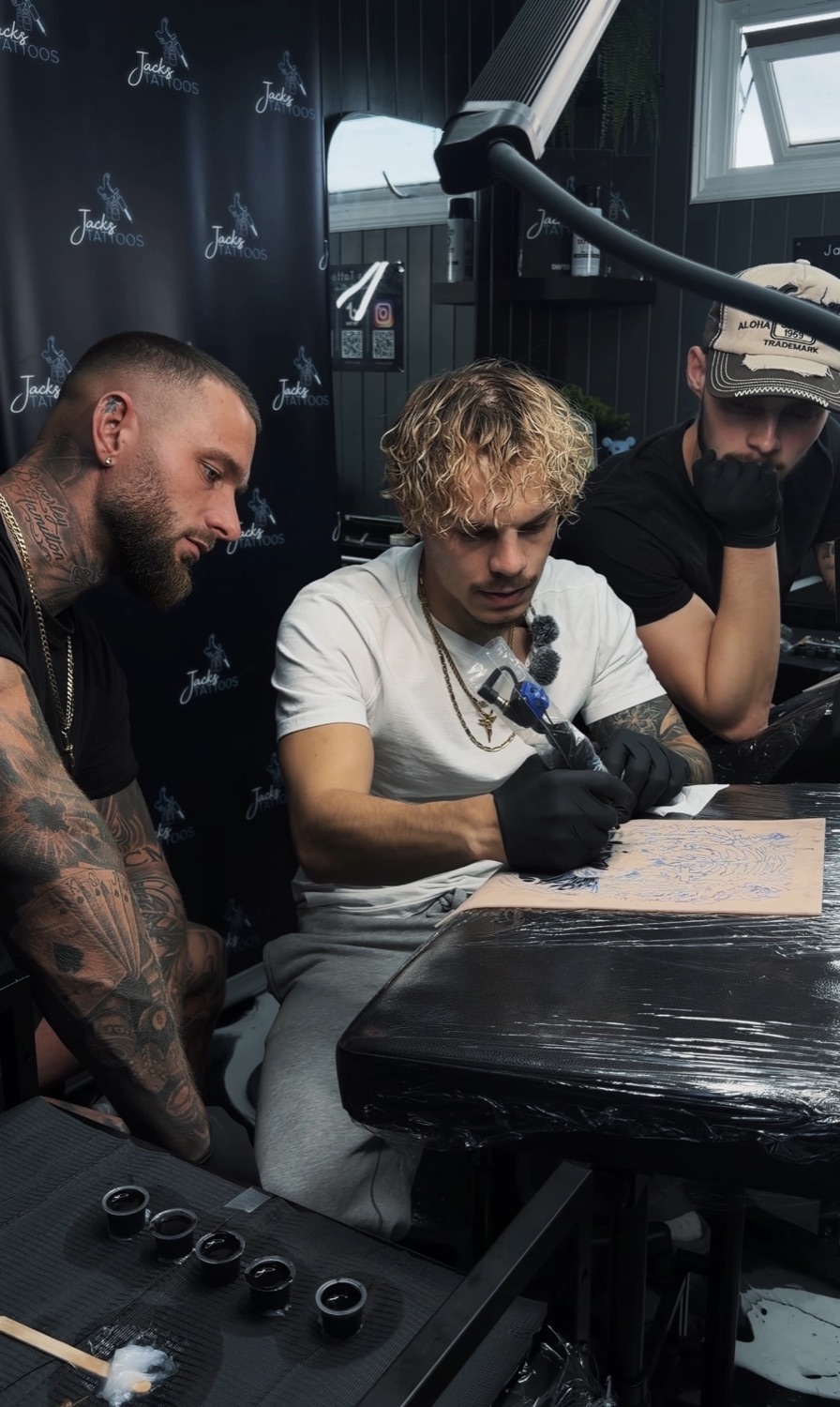 Jack preparing a stencil at the studio bench with fellow artists