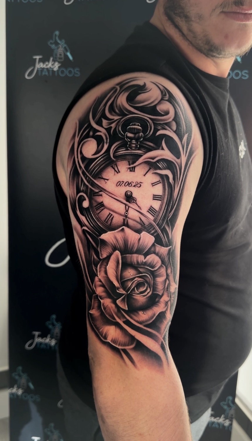 Black and grey pocket watch and rose upper arm tattoo