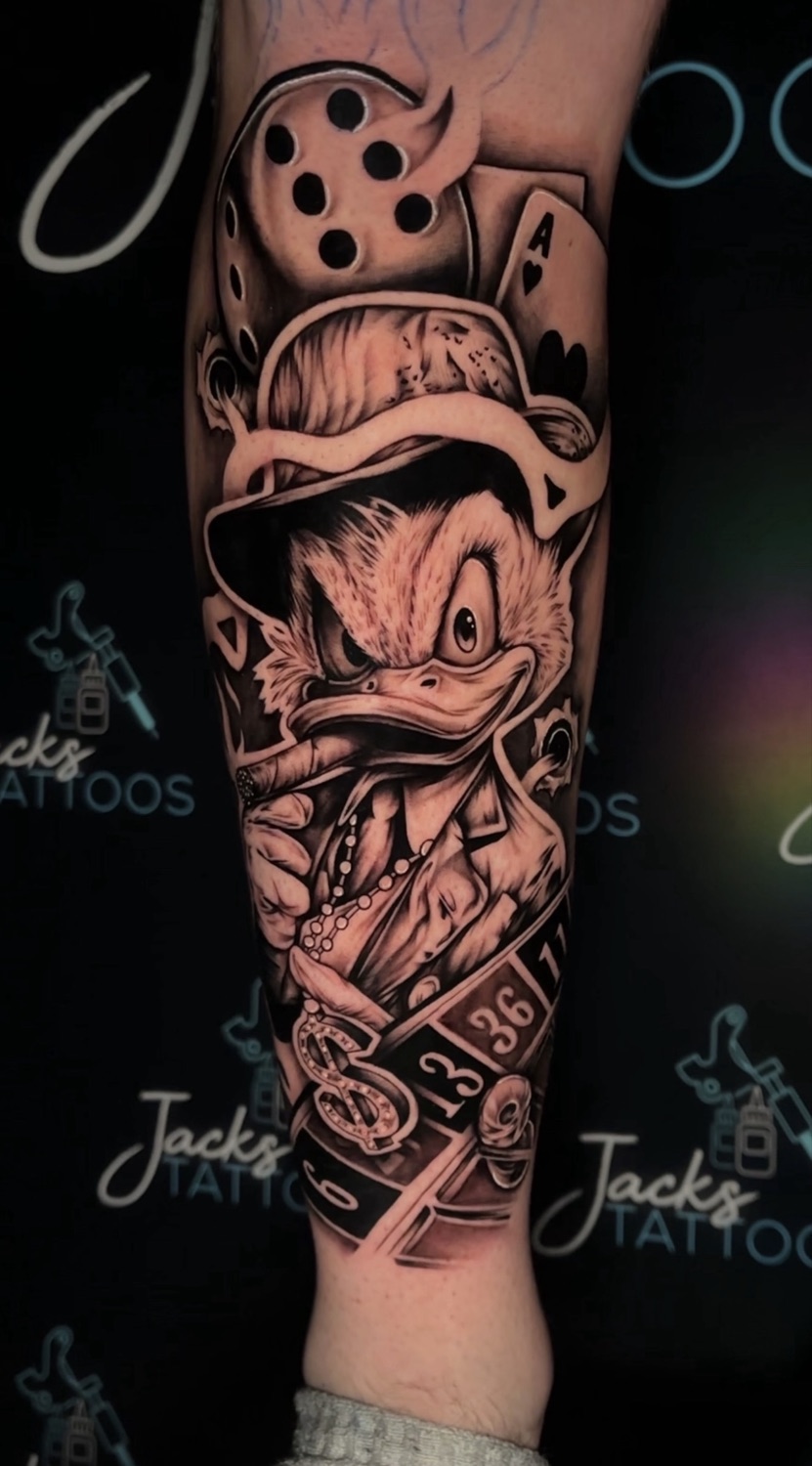 Black and grey gangster Scrooge McDuck with dice and cards forearm tattoo