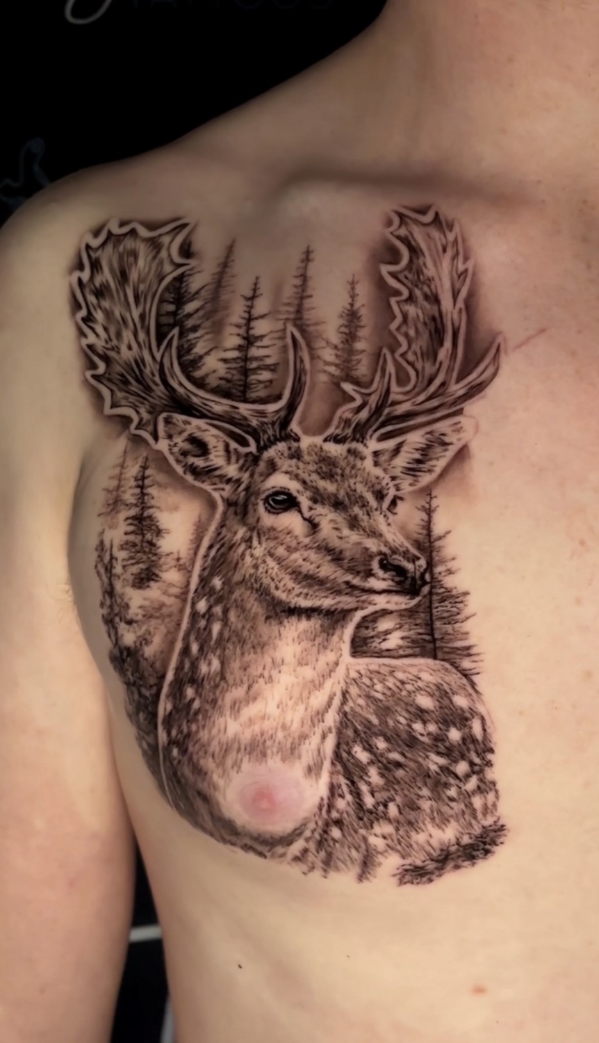 Black and grey stag and pine forest chest tattoo