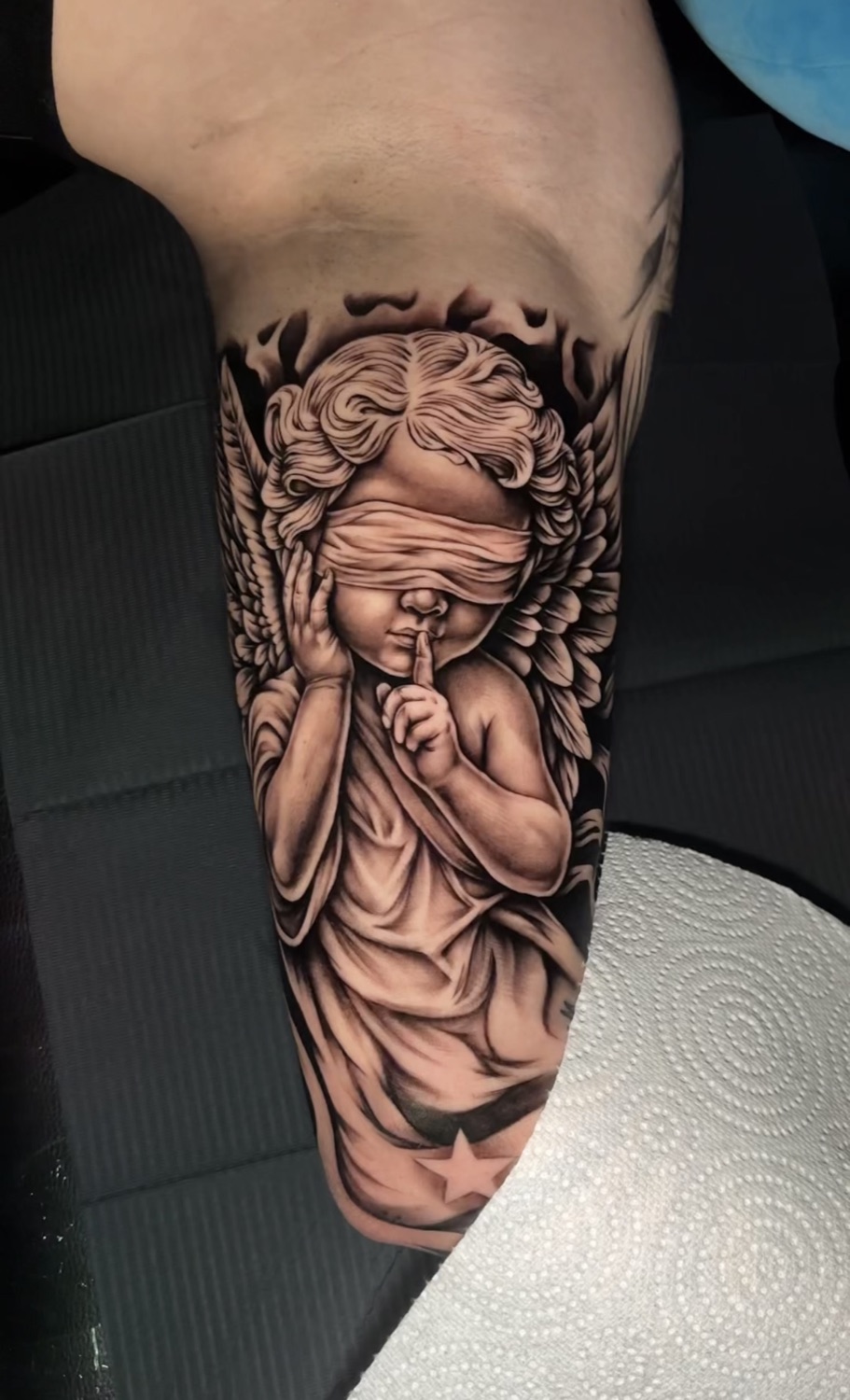Black and grey blindfolded cherub angel tattoo