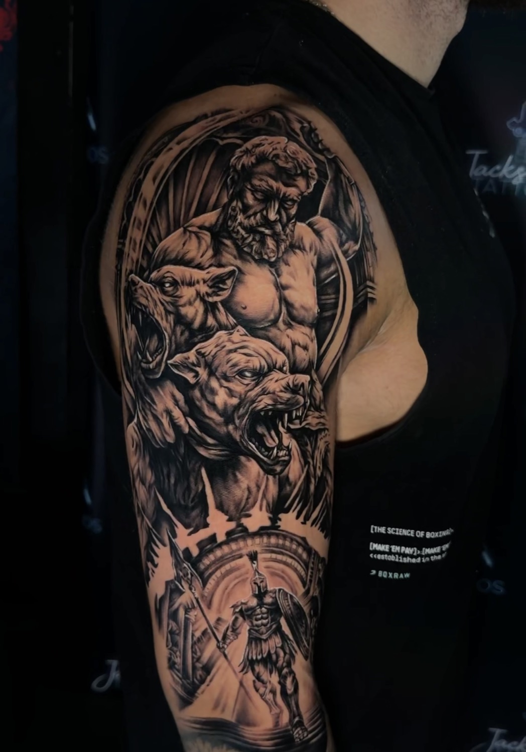 Black and grey Zeus and Poseidon with Spartan warrior upper arm tattoo