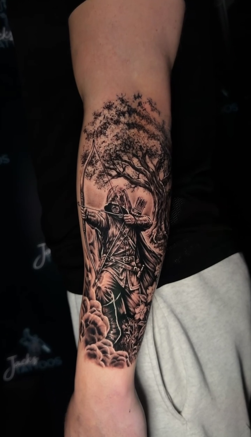 Black and grey samurai beneath a tree forearm tattoo