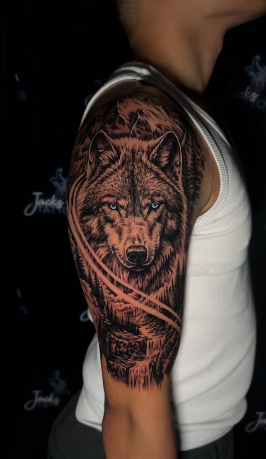 Black and grey wolf portrait upper arm tattoo