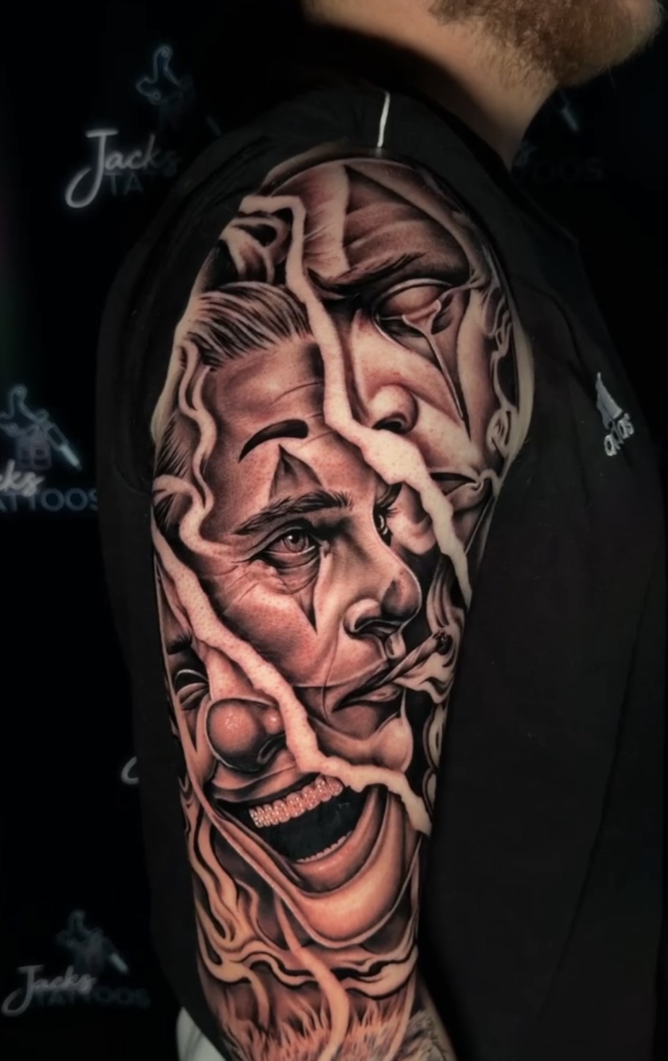 Black and grey Joker and Harley Quinn split-face upper arm tattoo