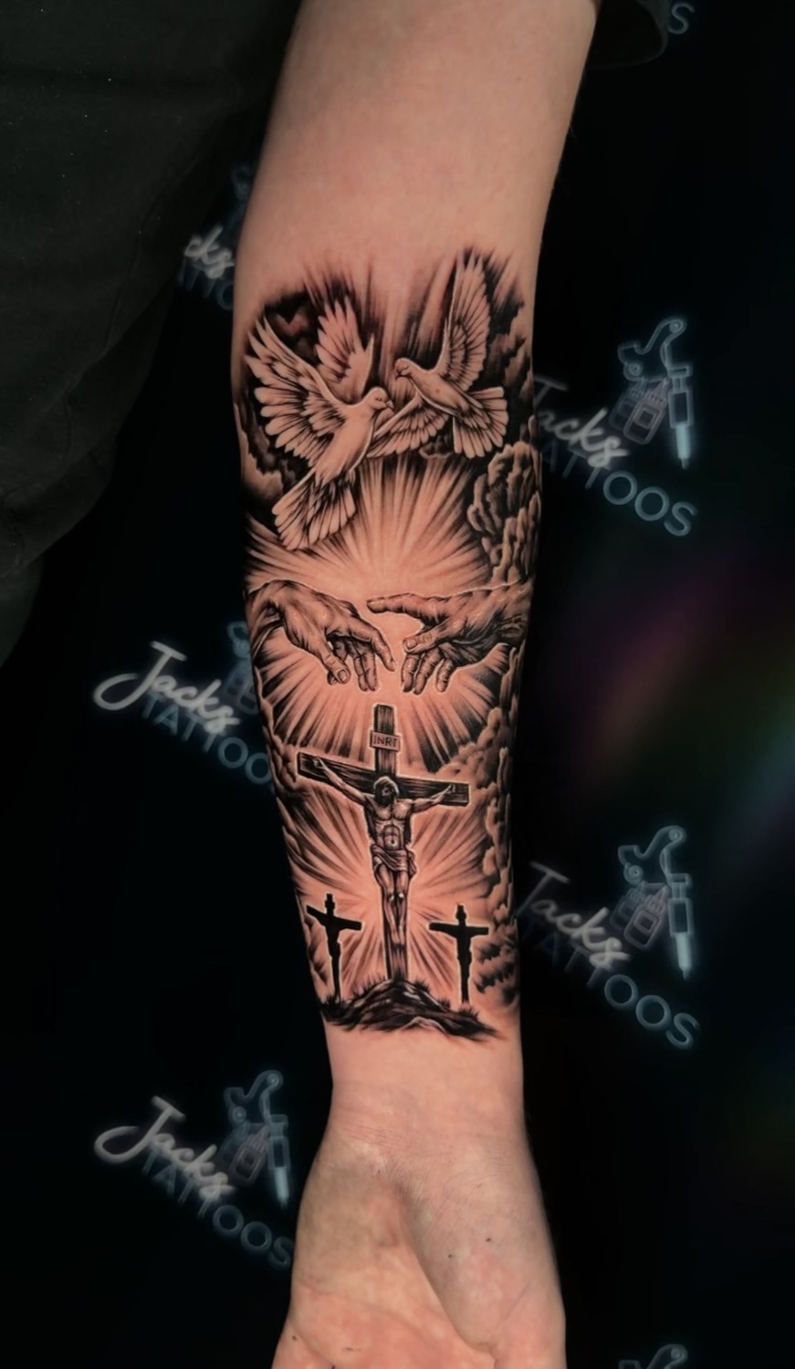 Black and grey dove and crucifixion scene forearm tattoo