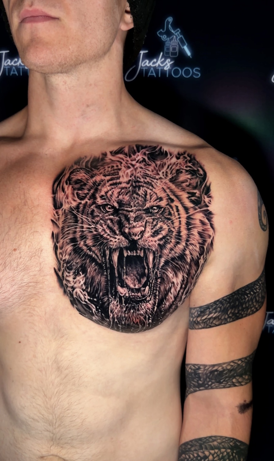 Black and grey roaring tiger chest piece and tribal arm band tattoo