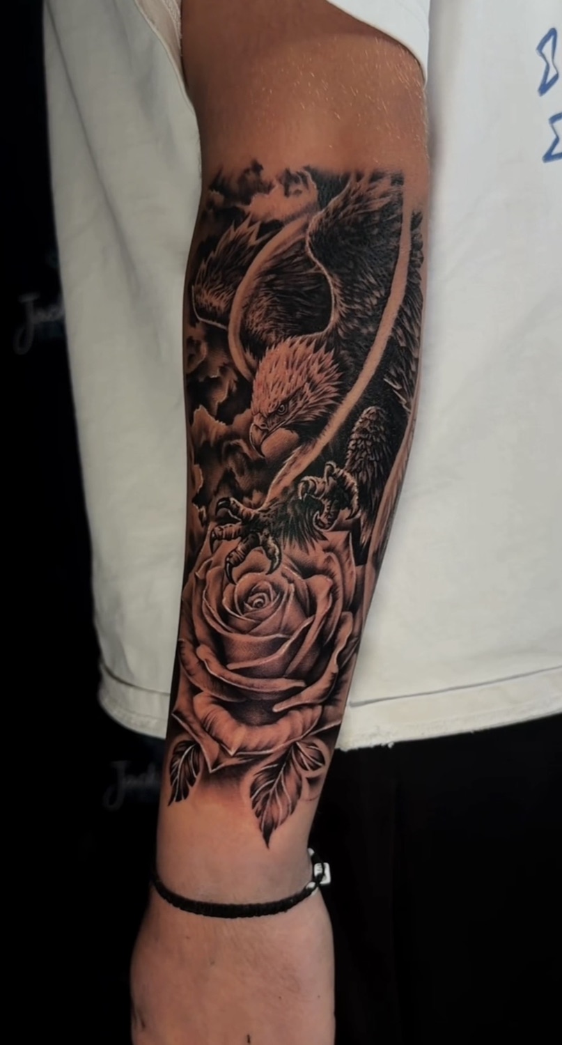 Black and grey eagle and rose forearm tattoo
