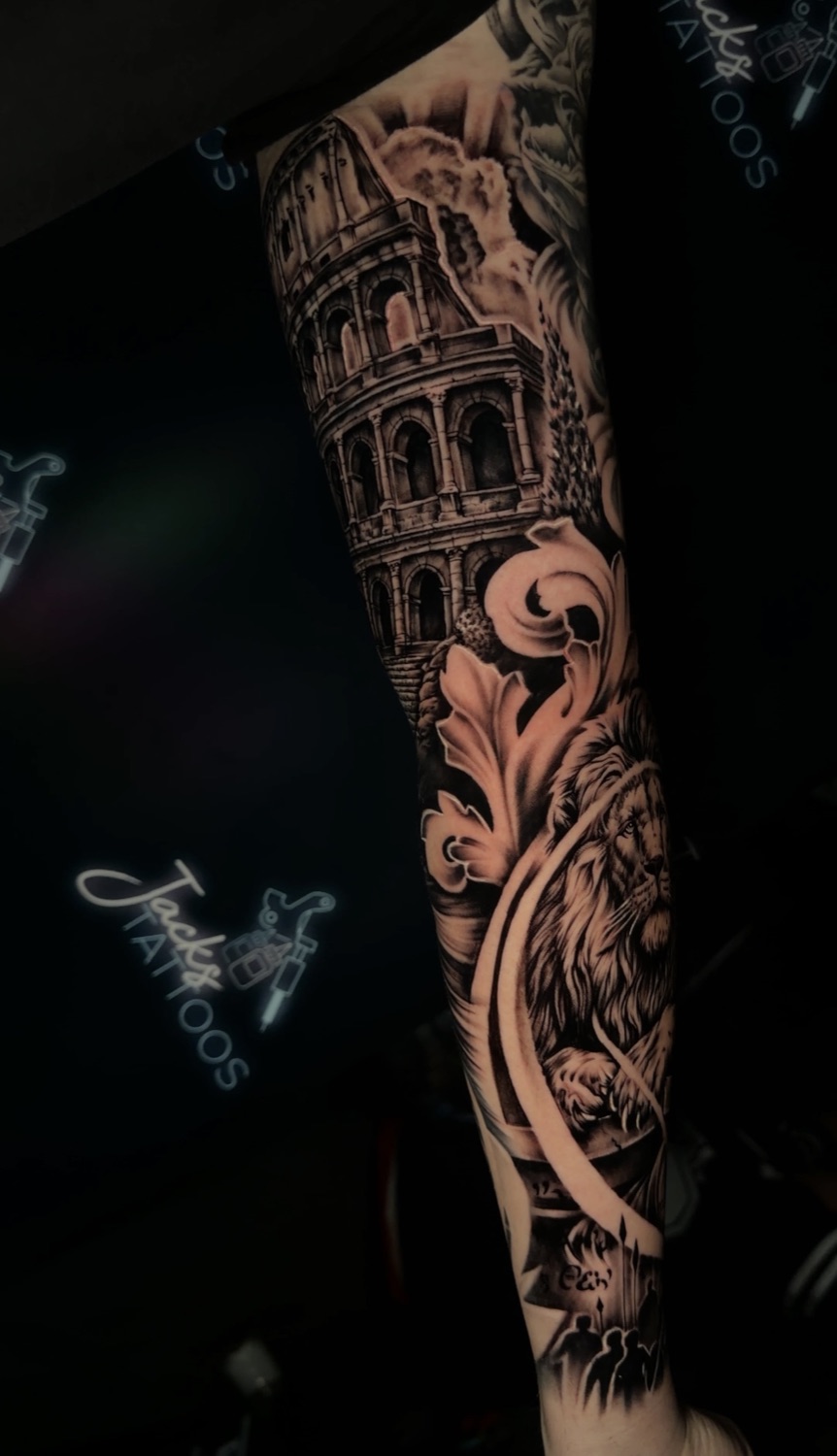 Black and grey Roman Colosseum and acanthus filigree forearm tattoo