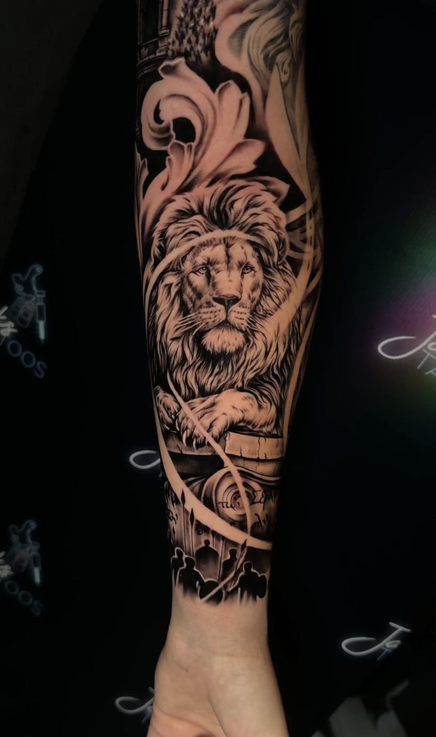 Black and grey lion portrait and baroque filigree forearm tattoo
