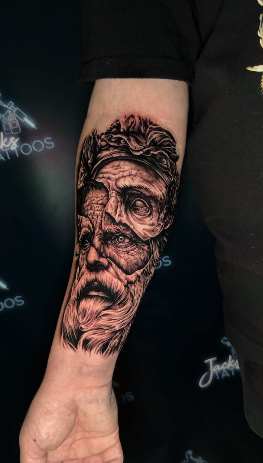 Black and grey Greek god portrait forearm tattoo