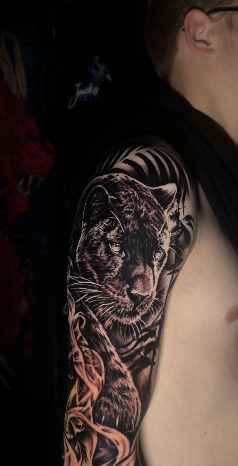 Black and grey leopard upper arm tattoo