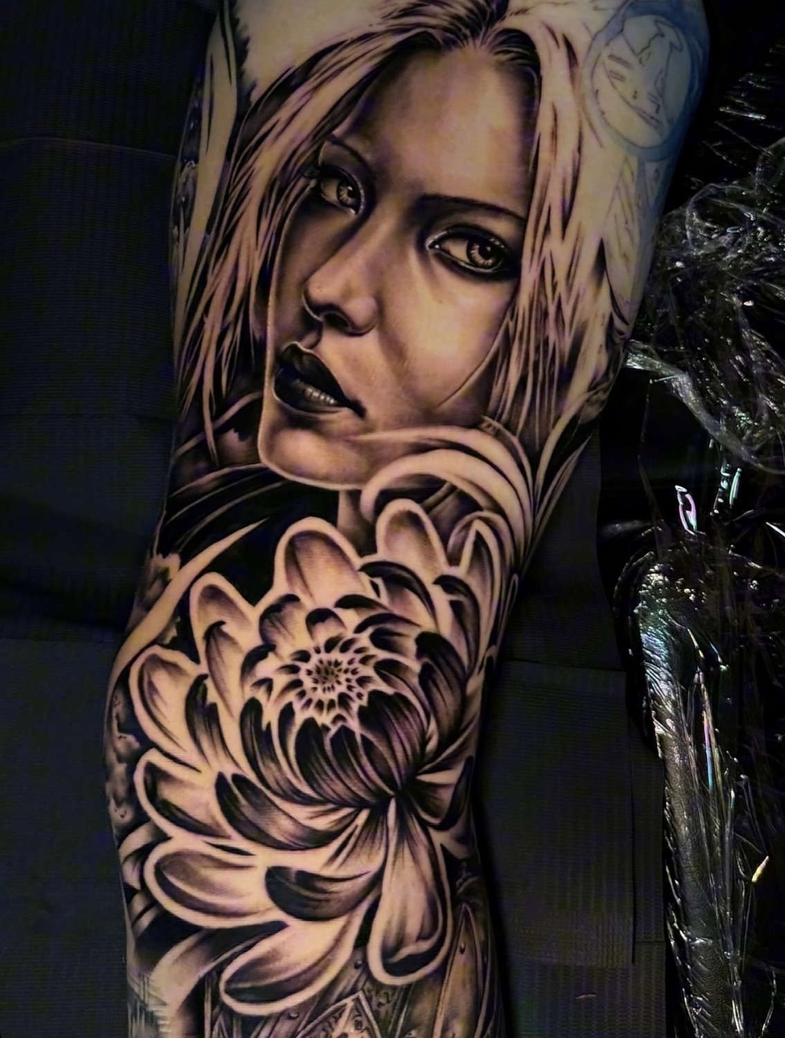 Black and grey woman portrait and chrysanthemum sleeve tattoo