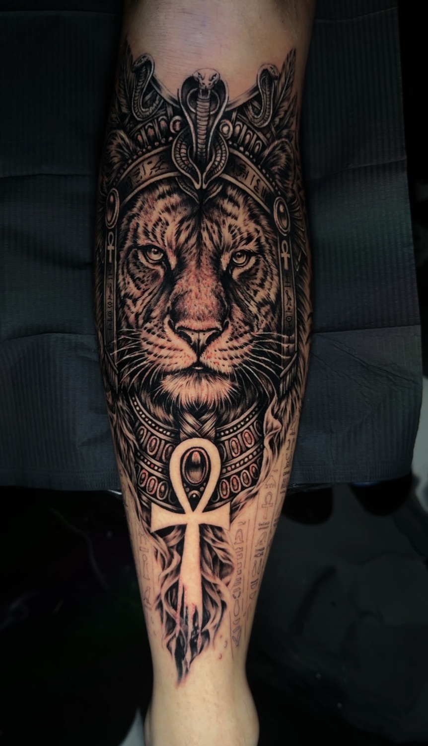 Black and grey Egyptian lion with ankh and cobra forearm tattoo