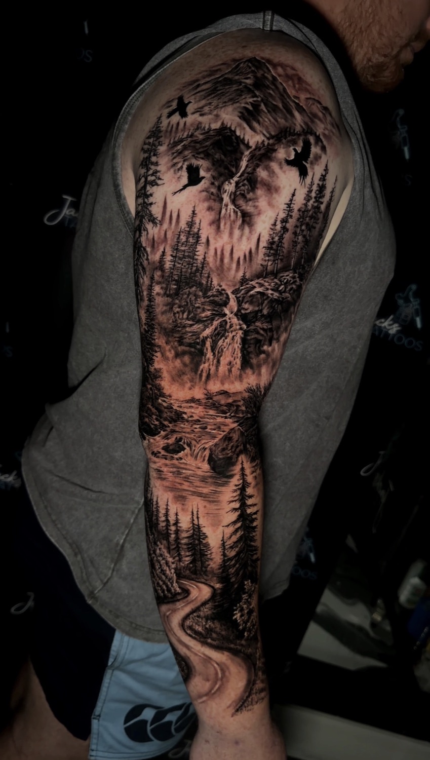 Black and grey forest, waterfall and mountain landscape full arm sleeve tattoo